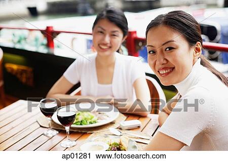 Two women sitting at table in cafe, looking at camera View Large Photo Image Stock Image - Two women sitting at table in cafe, looking at camera. Fotosearch