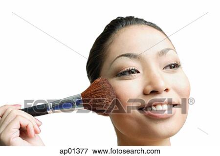 Stock Photo - Woman applying blusher with make-up brush. Fotosearch
