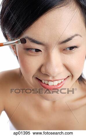 Stock Photography - Woman applying eyeshadow. Fotosearch