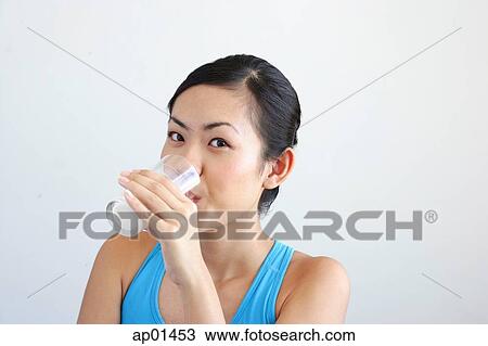 Woman drinking glass of milk, looking at camera View Large Photo Image Stock Image - Woman drinking glass of milk, looking at camera. Fotosearch