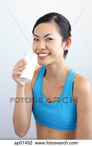 Woman drinking glass of milk, smiling at camera View Large Photo Image Stock Image - Woman drinking glass of milk, smiling at camera. Fotosearch
