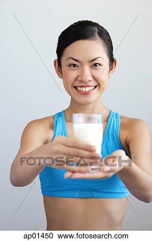 Stock Image - Woman holding glass of milk. Fotosearch