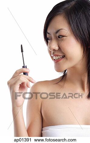 Stock Image - Woman holding mascara brush. Fotosearch