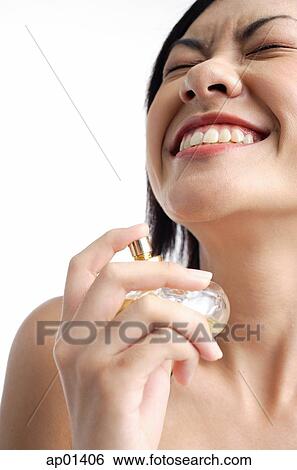 Woman holding perfume bottle, eyes closed, smiling View Large Photo Image Stock Photograph - Woman holding perfume bottle, eyes closed, smiling. Fotosearch