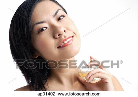 Woman holding perfume bottle, looking at camera View Large Photo Image Stock Image - Woman holding perfume bottle, looking at camera. Fotosearch