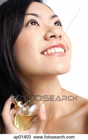 Woman holding perfume bottle, looking up View Large Photo Image Stock Image - Woman holding perfume bottle, looking up. Fotosearch