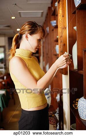 Woman in antique shop, browsing View Large Photo Image Stock Image - Woman in antique shop, browsing. Fotosearch