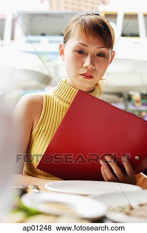Woman in cafe, looking at menu View Large Photo Image Stock Photo - Woman in cafe, looking at menu. Fotosearch