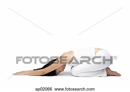 Stock Photograph - Woman kneeling on floor, doing yoga. Fotosearch