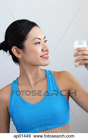 Woman looking at glass of milk View Large Photo Image Stock Photo - Woman looking at glass of milk. Fotosearch