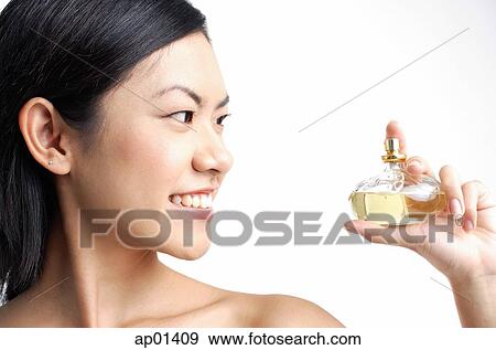 Woman looking at perfume bottle View Large Photo Image Stock Photo - Woman looking at perfume bottle. Fotosearch