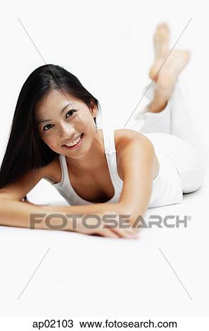 Woman lying on front, legs crossed at the ankle, smiling at camera View Large Photo Image Stock Image - Woman lying on front, legs crossed at the ankle, smiling at camera. Fotosearch
