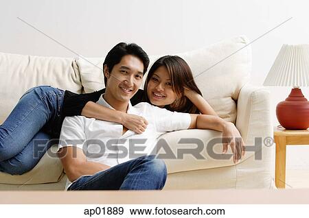 Woman lying on sofa, man sitting on floor in front of her View Large Photo Image Stock Photo - Woman lying on sofa, man sitting on floor in front of her. Fotosearch