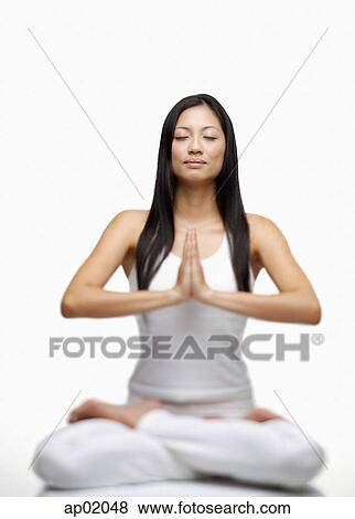 Woman practicing yoga, sitting in lotus position, hands together View Large Photo Image Stock Photo - Woman practicing yoga, sitting in lotus position, hands together. Fotosearch