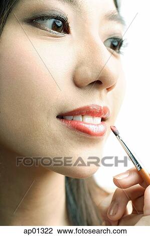Woman putting on lipstick with lip brush View Large Photo Image Stock Image - Woman putting on lipstick with lip brush. Fotosearch