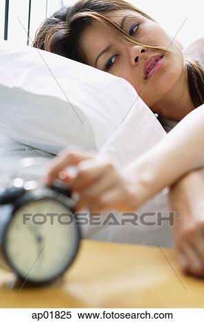 Woman reaching to switch off alarm clock View Large Photo Image Stock Photography - Woman reaching to switch off alarm clock. Fotosearch