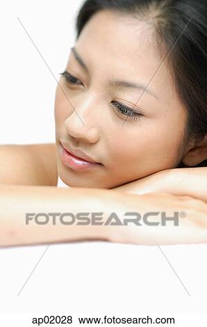 Woman resting face on arms, looking away View Large Photo Image Stock Photo - Woman resting face on arms, looking away. Fotosearch