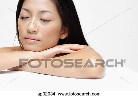 Woman resting head on arms, eyes closed View Large Photo Image Picture - Woman resting head on arms, eyes closed. Fotosearch