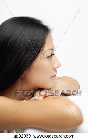 Woman resting head on arms, looking away, profile View Large Photo Image Stock Photo - Woman resting head on arms, looking away, profile. Fotosearch