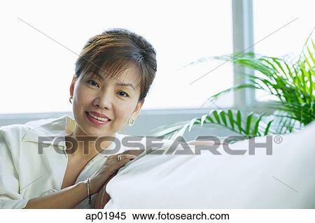 Woman sitting, looking at camera, portrait View Large Photo Image Stock Photography - Woman sitting, looking at camera, portrait. Fotosearch
