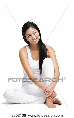 Stock Photograph - Woman sitting on floor, hugging knee, looking away. Fotosearch