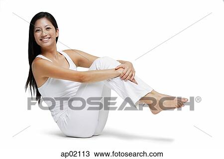 Woman sitting on floor, hugging knees, and lifting legs of floor, smiling View Large Photo Image Stock Image - Woman sitting on floor, hugging knees, and lifting legs of floor, smiling. Fotosearch