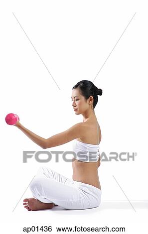 Woman sitting on floor, lifting dumbbells View Large Photo Image Stock Photograph - Woman sitting on floor, lifting dumbbells. Fotosearch