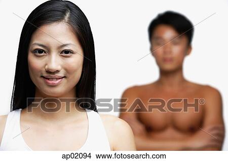 Picture - Woman smiling at camera, person in the background. Fotosearch