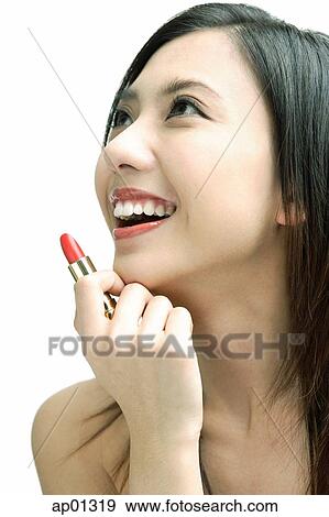 Woman smiling looking away, holding lipstick View Large Photo Image Stock Photo - Woman smiling looking away, holding lipstick. Fotosearch