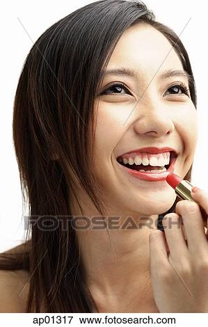 Woman smiling, putting on lipstick View Large Photo Image Stock Photo - Woman smiling, putting on lipstick. Fotosearch