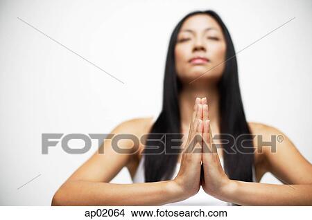 Picture - Woman with hands together, eyes closed. Fotosearch