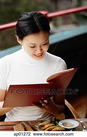 Stock Image - Women in cafe, reading menu. Fotosearch