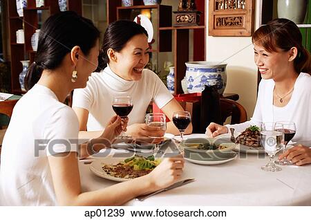 Stock Photo - Women in restaurant, sitting at table, talking. Fotosearch