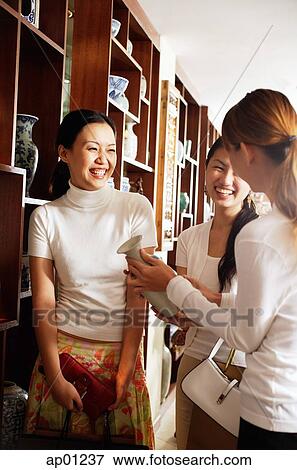 Women laughing, standing in antique shop View Large Photo Image Stock Photo - Women laughing, standing in antique shop. Fotosearch