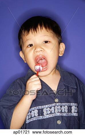 Young boy eating lollypop View Large Photo Image Stock Image - Young boy eating lollypop. Fotosearch