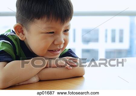 Young boy looking away, leaning on arms View Large Photo Image Stock Photo - Young boy looking away, leaning on arms. Fotosearch