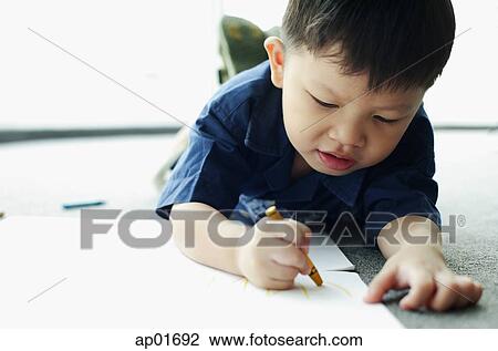 Young boy lying on floor, drawing with crayon View Large Photo Image Stock Image - Young boy lying on floor, drawing with crayon. Fotosearch