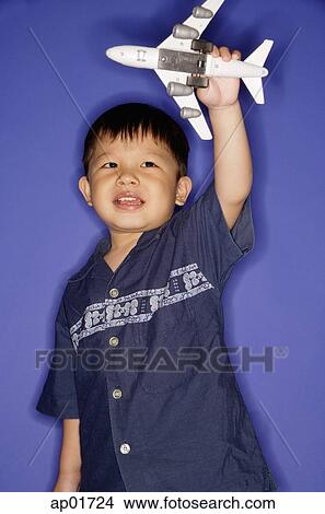 Young boy playing with toy airplane View Large Photo Image Picture - Young boy playing with toy airplane. Fotosearch