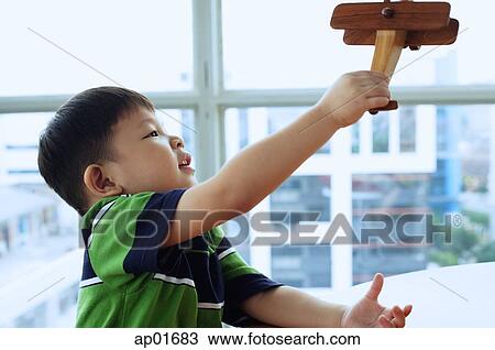 Young boy playing with toy airplane View Large Photo Image Stock Image - Young boy playing with toy airplane. Fotosearch
