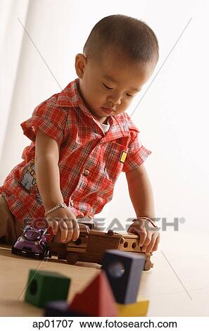 Young boy playing with toy train View Large Photo Image Stock Photo - Young boy playing with toy train. Fotosearch