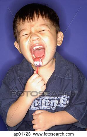 Young boy with lollypop, mouth open, eyes closed View Large Photo Image Stock Image - Young boy with lollypop, mouth open, eyes closed. Fotosearch