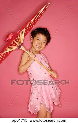 Stock Photography - Young girl in pink dress holding umbrella, smiling. Fotosearch