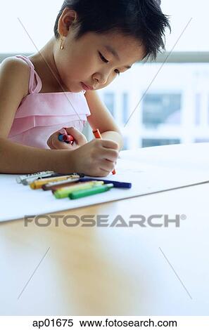 Young girl looking down, drawing with crayons View Large Photo Image Stock Photography - Young girl looking down, drawing with crayons. Fotosearch