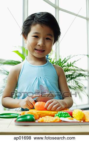 Young girl playing with plastic food, smiling at camera View Large Photo Image Stock Photo - Young girl playing with plastic food, smiling at camera. Fotosearch