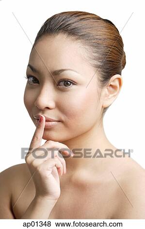Stock Photo - Young woman, finger on mouth. Fotosearch
