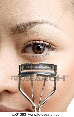 Young woman holding eyelash curler near eye, close up View Large Photo Image Stock Image - Young woman holding eyelash curler near eye, close up. Fotosearch