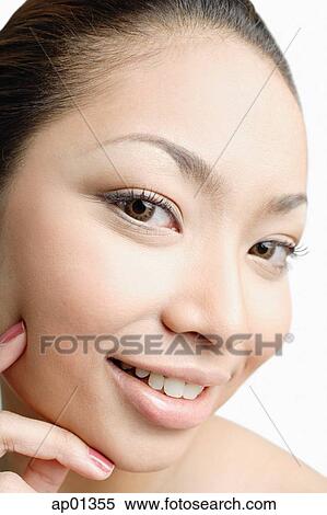 Young woman looking at camera, hand on face View Large Photo Image Stock Photography - Young woman looking at camera, hand on face. Fotosearch