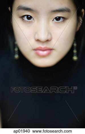 Young woman looking at camera, head shot View Large Photo Image Stock Image - Young woman looking at camera, head shot. Fotosearch