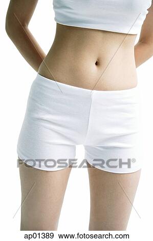 Stock Photo - Young woman, mid-section, hands behind back. Fotosearch
