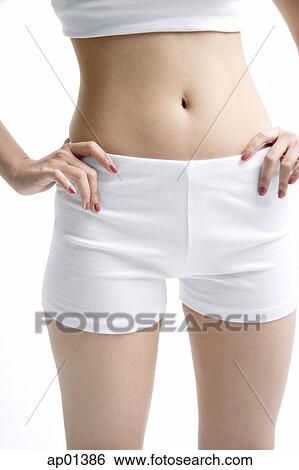 Stock Photograph - Young woman standing, hands on waist. Fotosearch